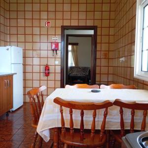 a kitchen with a table with chairs and a refrigerator at Yellow Owl II - Bedroom III in Campanário
