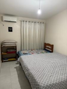 een slaapkamer met een bed en een raam met een gordijn bij Pousada Paraíso Central - Casinha in Rodeio