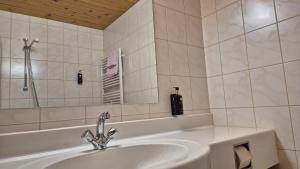 a white bathroom with a sink and a mirror at Hotel Dahoam by Miha in Westendorf +53 photos