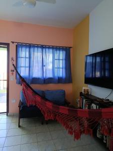 un hamac dans un salon avec une télévision dans l'établissement Casa Verde da Ari, à Ilha Comprida