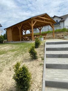 a wooden pavilion with a picnic table in a yard at Apartament SUNNY Rusinowo in Rusinowo +6 photos