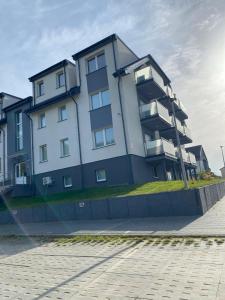 a large apartment building with balconies on the side of it at Apartament SUNNY Rusinowo in Rusinowo