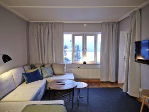 ein Wohnzimmer mit Sofa und Tisch in der Unterkunft AGO Nya Lundsgården in Åre