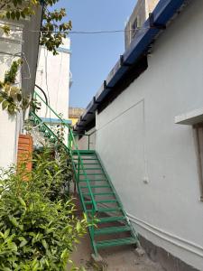 een groene trap naast een gebouw met een deur bij Nutan Homestay in Deoghar