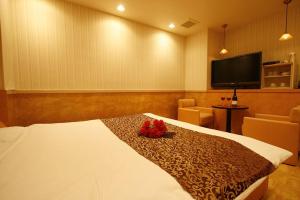 a hotel room with a bed with a television on the wall at ホテル彩柏市若柴店 in Kashiwa +18 photos