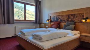 una camera da letto con due letti e una grande finestra di Hotel Dahoam by Miha a Westendorf