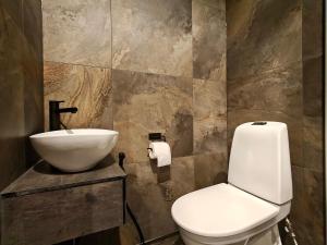 a bathroom with a white toilet and a sink at Peaceful Cabin with Hot Tub and Nature Views, Villa Lakeside Ruka in Ruka +23 photos