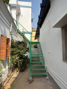 een trap met een groene leuning naast een gebouw bij Nutan Homestay in Deoghar