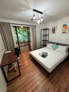 a bedroom with a bed and a desk and a window at Las casitas de Canggu in Canggu