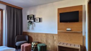 una camera d'albergo con TV a schermo piatto a parete di Hotel Dahoam by Miha a Westendorf
