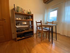 ein Esszimmer mit einem Tisch und einem Bücherregal in der Unterkunft FaWa Apartments "minimal" in Bruneck