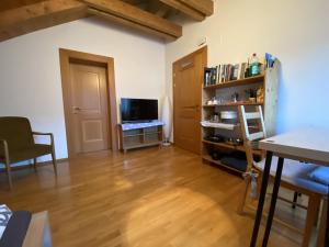 ein Wohnzimmer mit Holzboden und Fernseher in der Unterkunft FaWa Apartments "minimal" in Bruneck + 2 Fotos