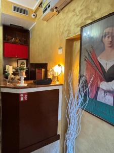 a painting of a woman on a wall next to a counter at Hotel Canal Salieri in Venice