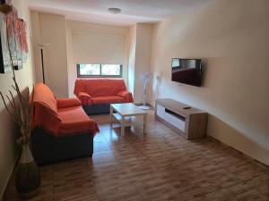 een woonkamer met een bank en een tv bij apartamentos la villa 3 in San Sebastián de la Gomera