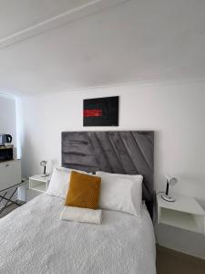 a bedroom with a white bed with a wooden headboard at Suuka Guest House in Walvis Bay