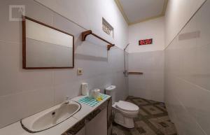 a white bathroom with a sink and a toilet at Pondok tulamben in Karangasem