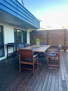 a wooden table and chairs on a deck at The Marlin House Iluka in Iluka