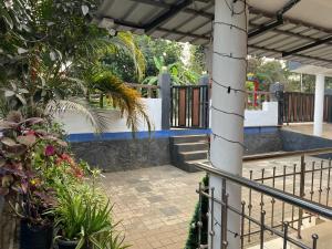 eine Terrasse mit Zaun und einigen Pflanzen in der Unterkunft Tulips villa in Mānantoddy