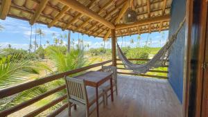 a porch with a hammock and a table and chairs at Vila Budião - Corumbau in Corumbau