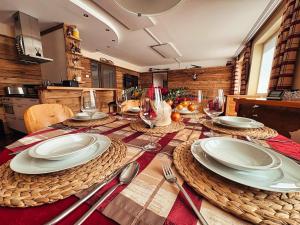 a dining room table with plates and wine glasses at ALPENLOFT vom Berg zum See inklusive gratis KärntenCard in Kanzelhöhe +51 photos