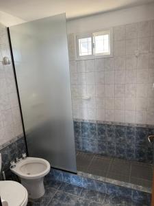 a bathroom with a toilet and a shower stall at Bajada 1 in Las Grutas