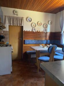 une cuisine avec une table, des chaises et des assiettes murales dans l'établissement Chata na Polane, à Otilia