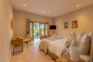 a bedroom with a bed and a desk and a television at Villa Nour in Marrakesh
