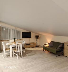 een woonkamer met een tafel en een bank bij Ronnenburg apartamenti in Rauna