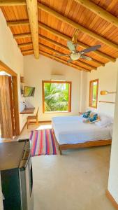 a bedroom with a bed and a ceiling fan at Vila Budião - Corumbau in Corumbau