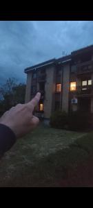una mano che indica un edificio con le luci accese di Apartman Branko Radicević a Negotin