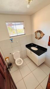 a bathroom with a toilet and a sink at Mansão suíça nos campos - Perto das praias in Aquiraz +28 photos