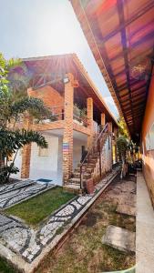 a house with a roof with a staircase in front of it at Mansão suíça nos campos - Perto das praias in Aquiraz
