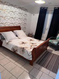 a bedroom with a large bed with a wooden frame at Fleur de Canne in Saint-Benoît