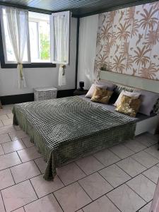 a bedroom with a large bed in a room at Fleur de Canne in Saint-Benoît