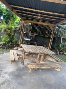 a picnic table and bench under a pavilion at Fleur de Canne in Saint-Benoît