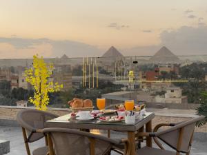 a table with food on it with a view of pyramids at La Veranda Pyramids View Hotel in Cairo +226 photos
