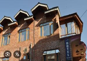 a brown brick building with a roof at Hotel taimoor in Srinagar