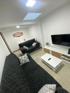 een woonkamer met een bank en een flatscreen-tv bij Casa Navia in Villanueva de Arosa