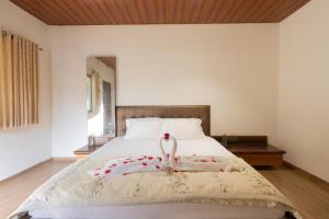 a bedroom with a bed with a swan on it at Glory of MJ, Family Resort in Nature, Panvel in Panvel +47 photos