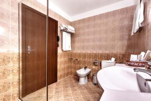 een badkamer met een bad, een toilet en een wastafel bij Спа Хотел Орфей in Devin