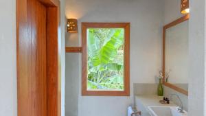 a bathroom with a mirror and a sink and a window at Vila Budião - Corumbau in Corumbau +136 photos