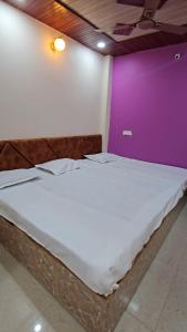 En eller flere senge i et værelse på Shri Mahakaleshwar Homestay