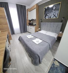a bedroom with a large bed with two towels on it at AchiDav 133 in Onești