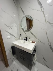 a bathroom with a sink and a mirror at Licht & ruim 2-slaapkamer appartement met airco & Wifi - rustig wijk Marrakesh in Marrakesh