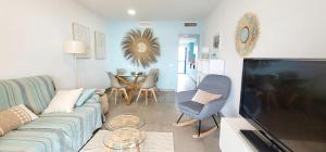 a living room with a couch and a tv at Blue Beach Apartment in Ifach