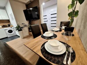 a dining room table with plates and glasses on it at Apartament Polna 21 in Kalisz