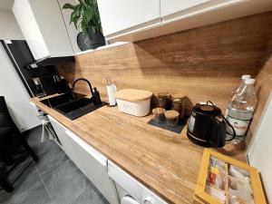 a kitchen with a counter with a sink and a stove at Apartament Polna 21 in Kalisz