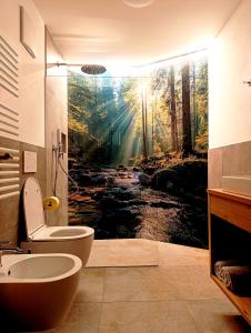 a bathroom with a painting of a forest at Binterhof in Castelrotto