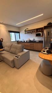 a living room with a couch and a kitchen at Smart Residence Moderno in Santarém