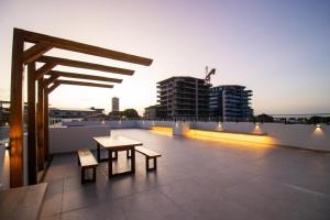 a rooftop with a table and benches on a building at Smart Residence Moderno in Santarém